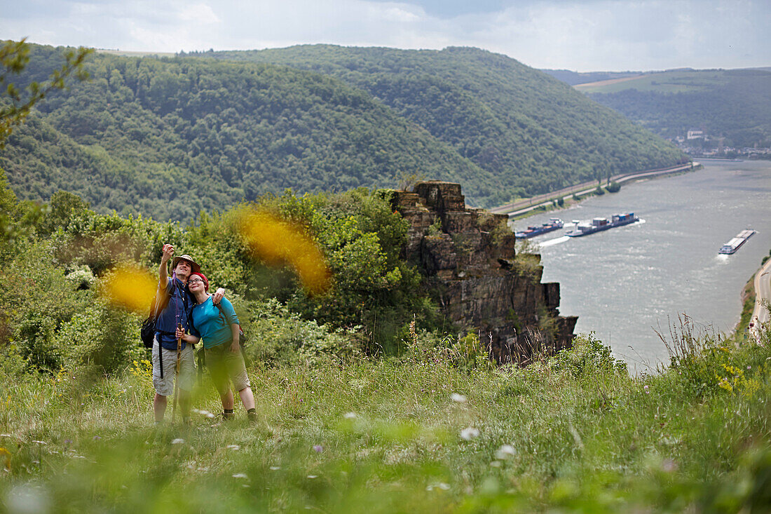 Wanderer auf Aussichtsfelsen Spitznack, Rhein im Hintergrund, Oberwesel, Rheinland-Pfalz, Deutschland