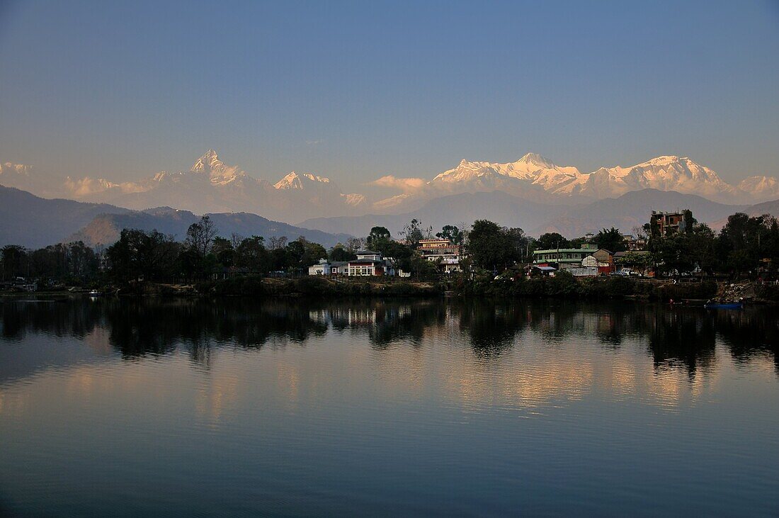 The major peaks of Annapurna is reflected in the lake at sunset in Pokhara, Nepal.