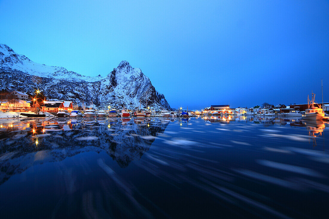 Port of Svolvear , Lofoten Islands, Norway, Small pieces of ice floating in the nordic sea, Boats moored and in the background big mountain