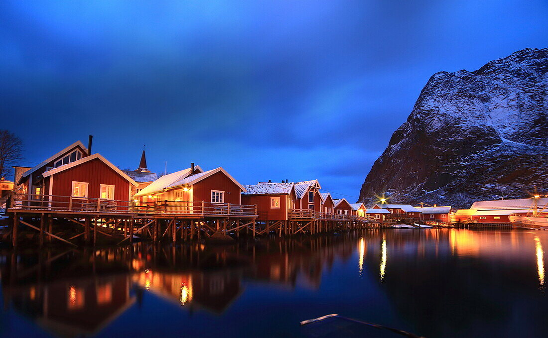 Houses on the Norwegian sea, very much like stilts, reflected on the sea in the port of Reine. Lofoten Islands