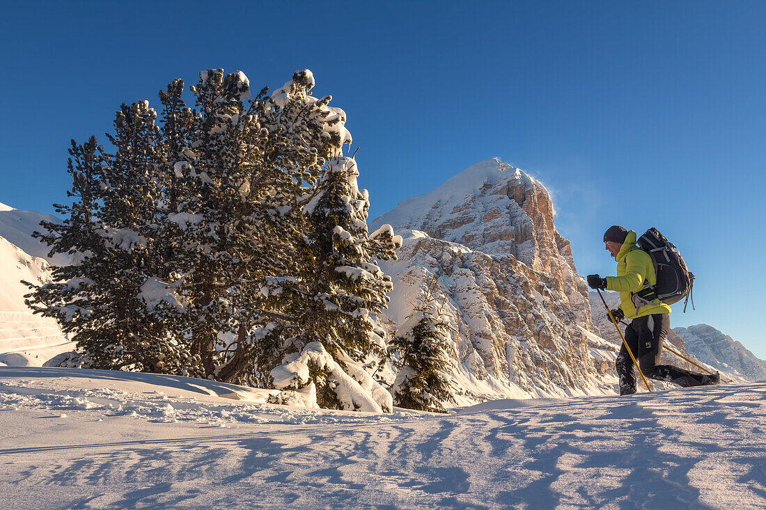 An hiker with snowshoes is walking in a winter's Dolomites landscape, Dolomites, Italy