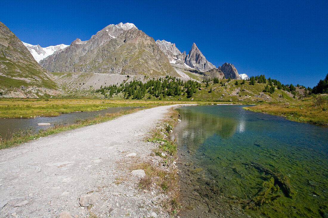 The path between glacial lakes in Veny Valley, with the Mont Blanc massif in the background, Veny Valley, Aosta valley