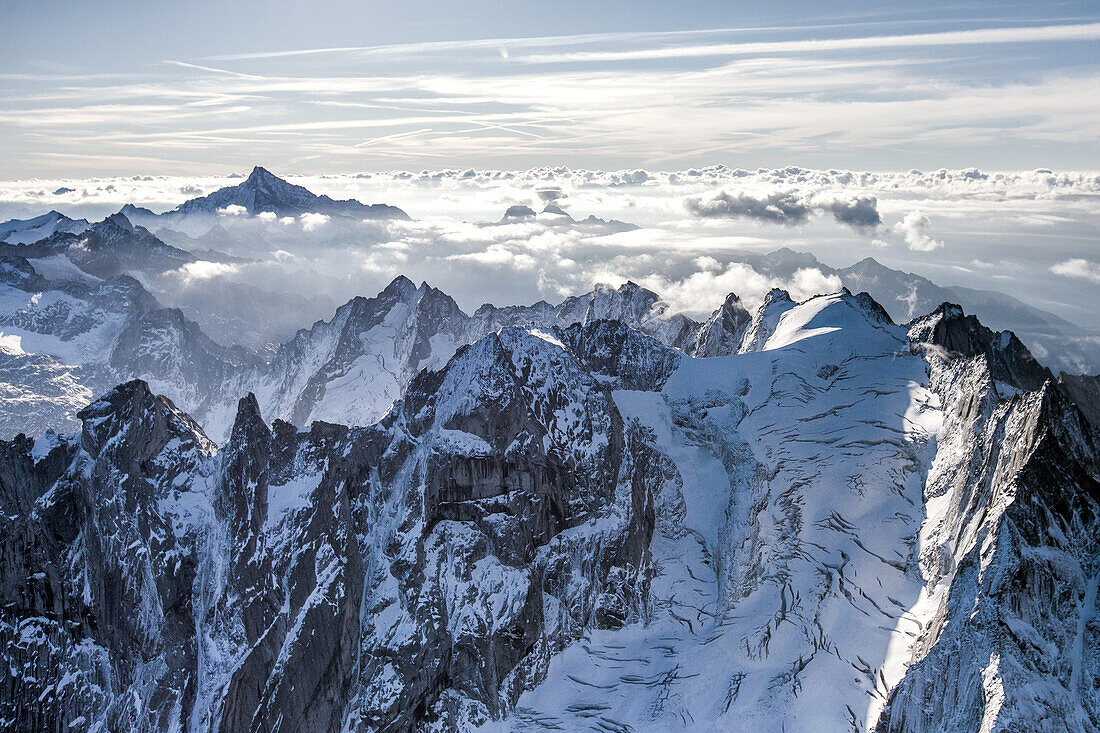 Border ridge between Bregaglia valley , Switzerland and Masino valley , Italy from helicopter. On the right the Bondasca summit with its glacier and crevasses. In the background the mount Disgrazia, Alps, Switzerland