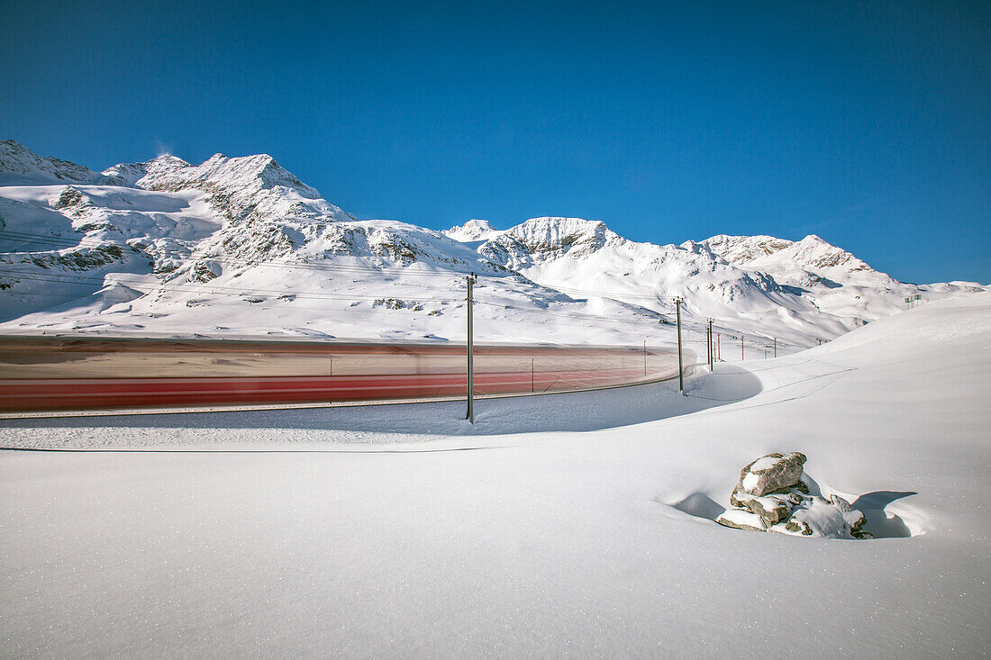 The Bernina Express , UNESCO World Heritage Site crossing the Bernina pass and its mighty glacier during the winter season, Engadin, Swiss Canton of Graubünden, Switzerland