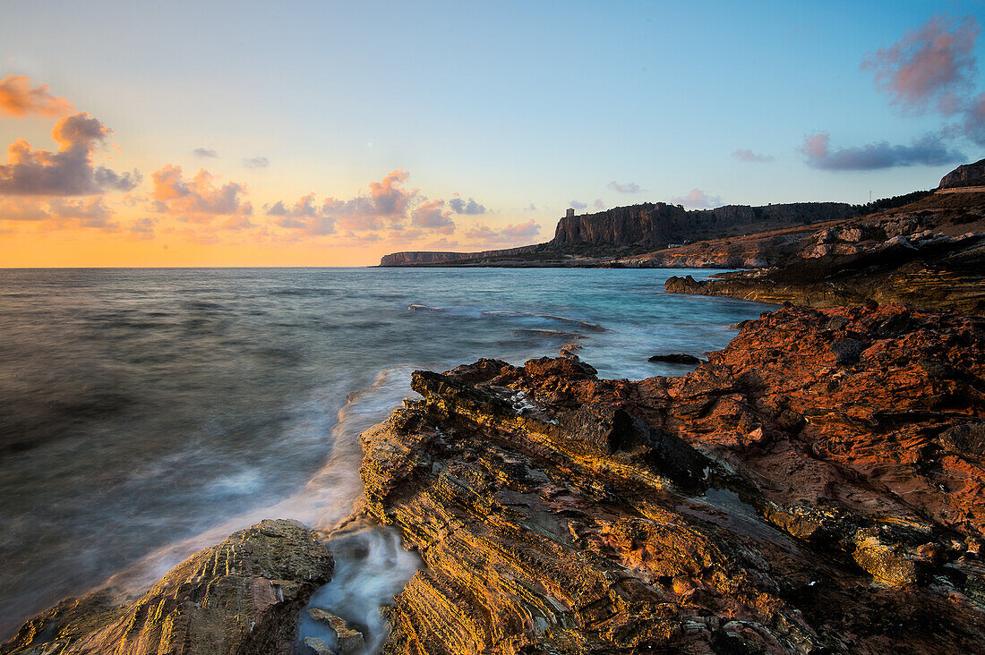 A view of the cliffs of San Vito lo Capo, on the sea at sunset