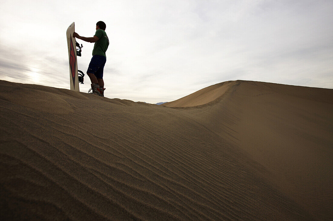 Lone  sand boarder stands a top one of the dunes.