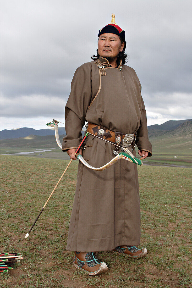 Mounted archer dressed as Genghis Khan warrior firing famous Mongolian bow.  Orkhon Valley, Central Mongolia.
