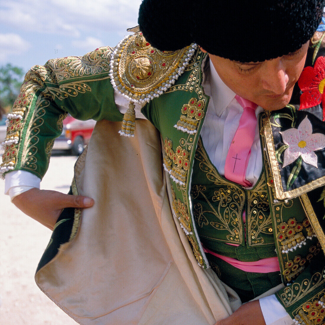 Matador Enriqué Delgado wraps himself in his parade cape prior to entering the Santa Maria Bullring. This ceremonial cape is hand made by close family members, so when a bullfighter wraps himself in the cape, he is really wrapping himself in his family an