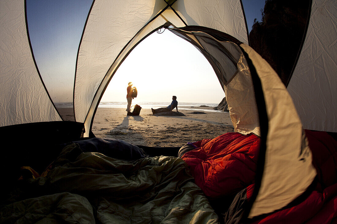 Maren Ludwig and Brad Hill watching the sunset while camping at Hug Point on the Oregon Coast.