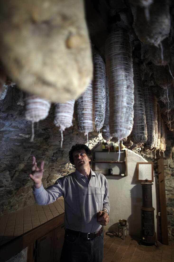 Izidor Skerlj shows their cellar holding cured meats at the Skerlj family tourist farm. They butcher their own meat, and grow their own vegetables to serve guests.