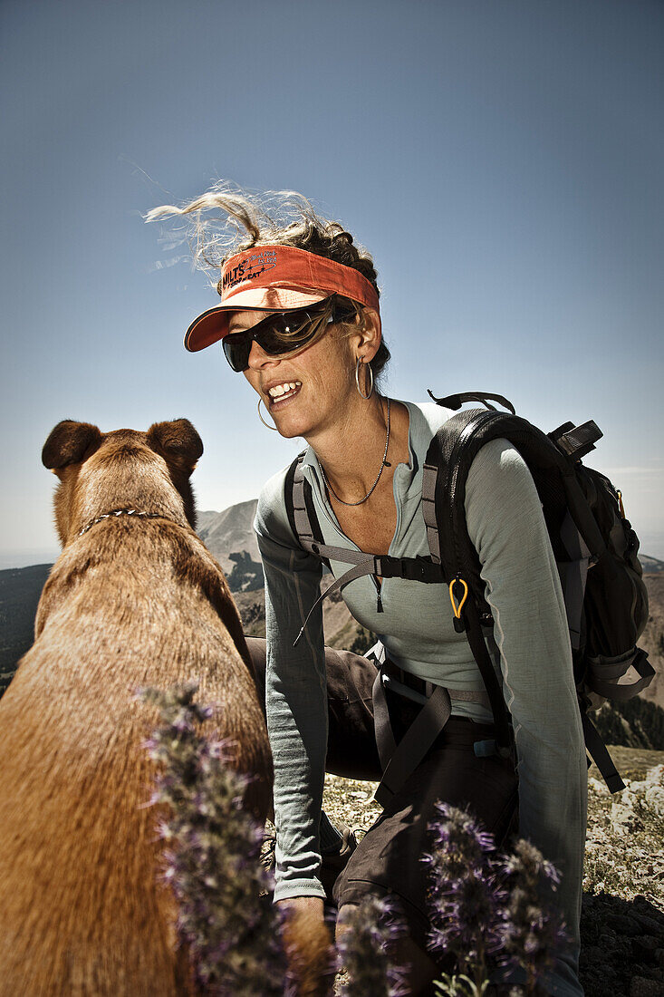 Kristi Jensen and her dog taking a break while climbing Manns Peak, La Sal mountains, Moab, Utah.