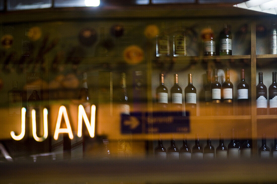 Wine bottles reflect in the windows with optical store signs across the street at the Miramar cafe in Buenos Aires. The venerable cafe, started as a small grocer early in the last century, is a favorite haunt of the area's tango dancers and culinary afici