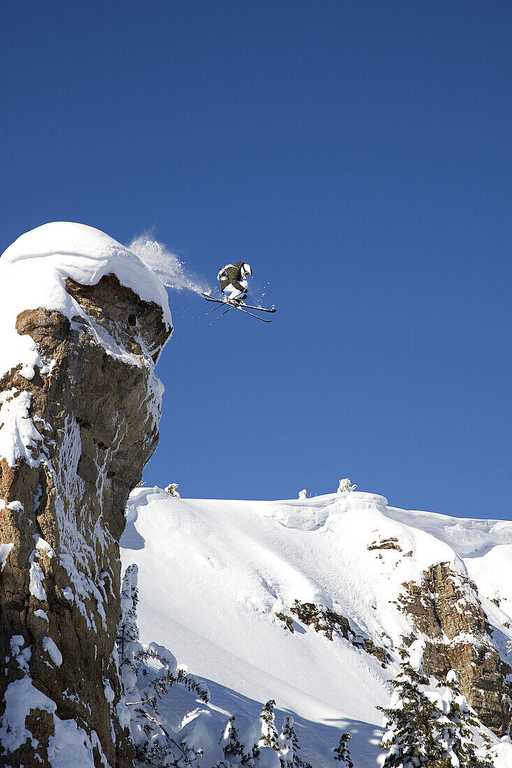 A male skier jumps off a 100 foot cliff known as the diving board in the Grand Targhee Backcountry, Wyoming.