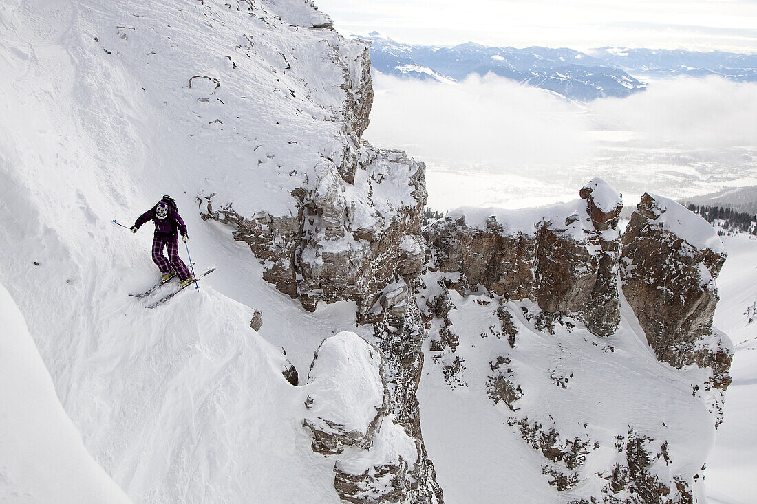 A female skier drops into the 60 degree entrance of Once is Enough Couloir in the Jackson Hole Mountain Resort backcountry, Wyoming.