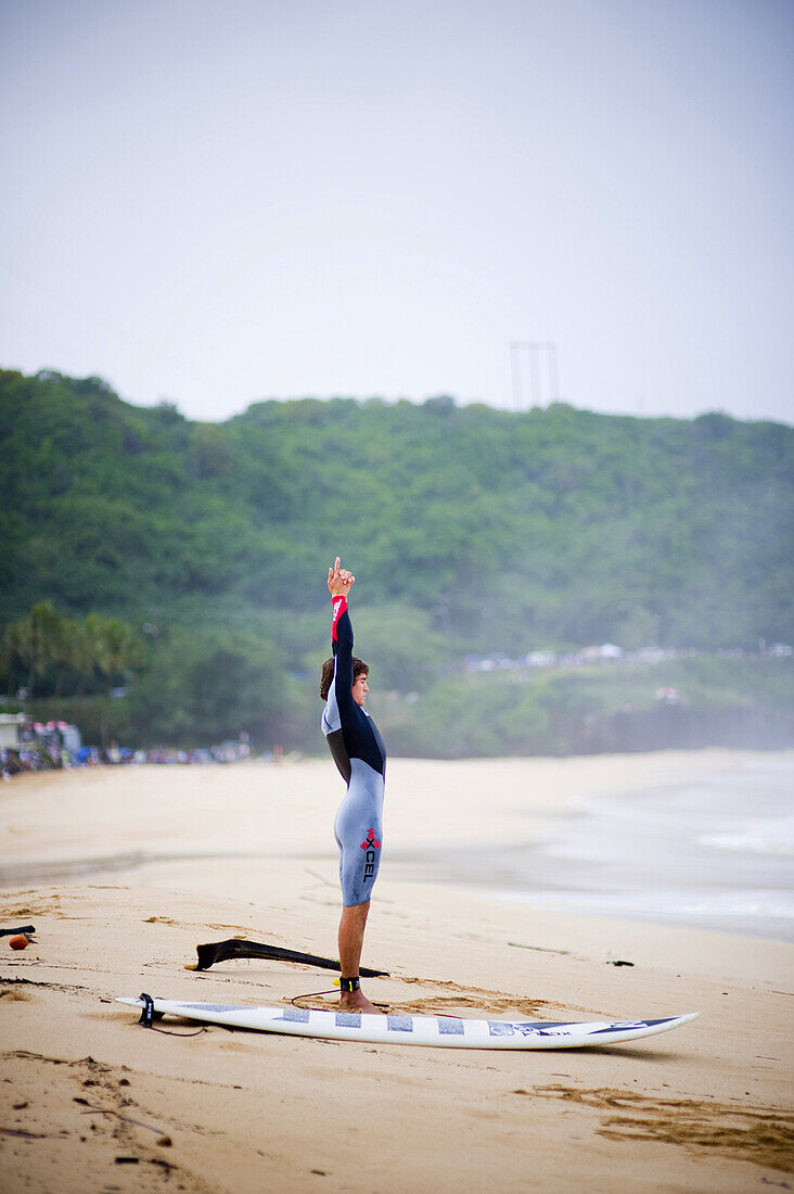 A surfer stretches before taking on the massive waves a day before the 25th Eddie Aikau Big Wave Invitational. The biggest swell on the North Shore for 10 years brought 30-50 foot waves at Waimea Bay, Hawaii.