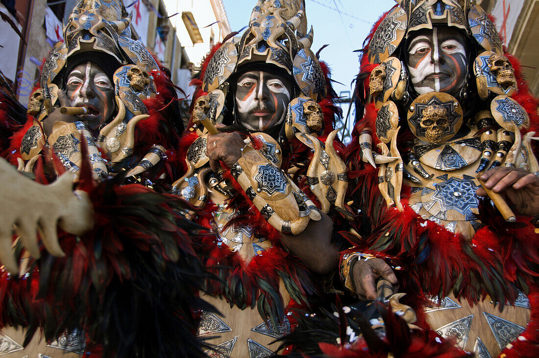 Men dressed in elaborate costumes, loosely representing North African tribes, the Moors, smoke cigars while marching in a parade during the Festival of Moors and Christians, La Fiesta de Moros y Cristianos, in the old town of Alcoy, Alicante Province, Val
