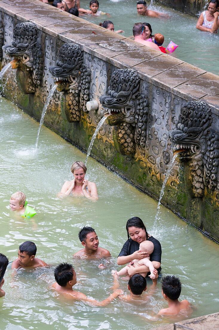 Balinesen und Deutsche baden, heiße Quellen bei Lovina, Air Panas, Balinesen spielen mit Baby, Wasser speiende balinesische Skulpturen, Kontakt mit Einheimischen, interkulturell, Urlauber, Touristen, schwimmen, lachen, Junge 3 Jahre alt, Baby 5 Monate alt