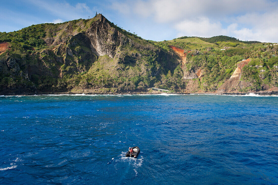 Zodiac raft from expedition cruise ship MS Hanseatic (Hapag-Lloyd Cruises) and rugged island coastline, Pitcairn, Pitcairn Group of Islands, British Overseas Territory, South Pacific