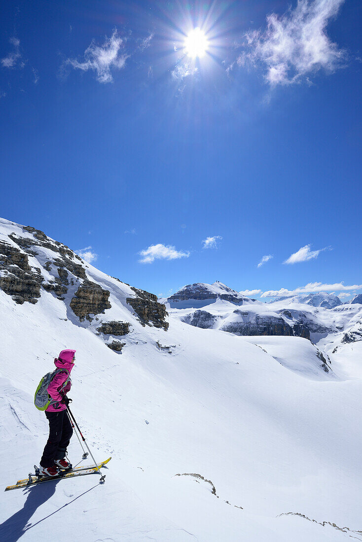 Female back-country skier looking to Sella Group with Piz Boe, Sella Group, Dolomites, South Tyrol, Italy