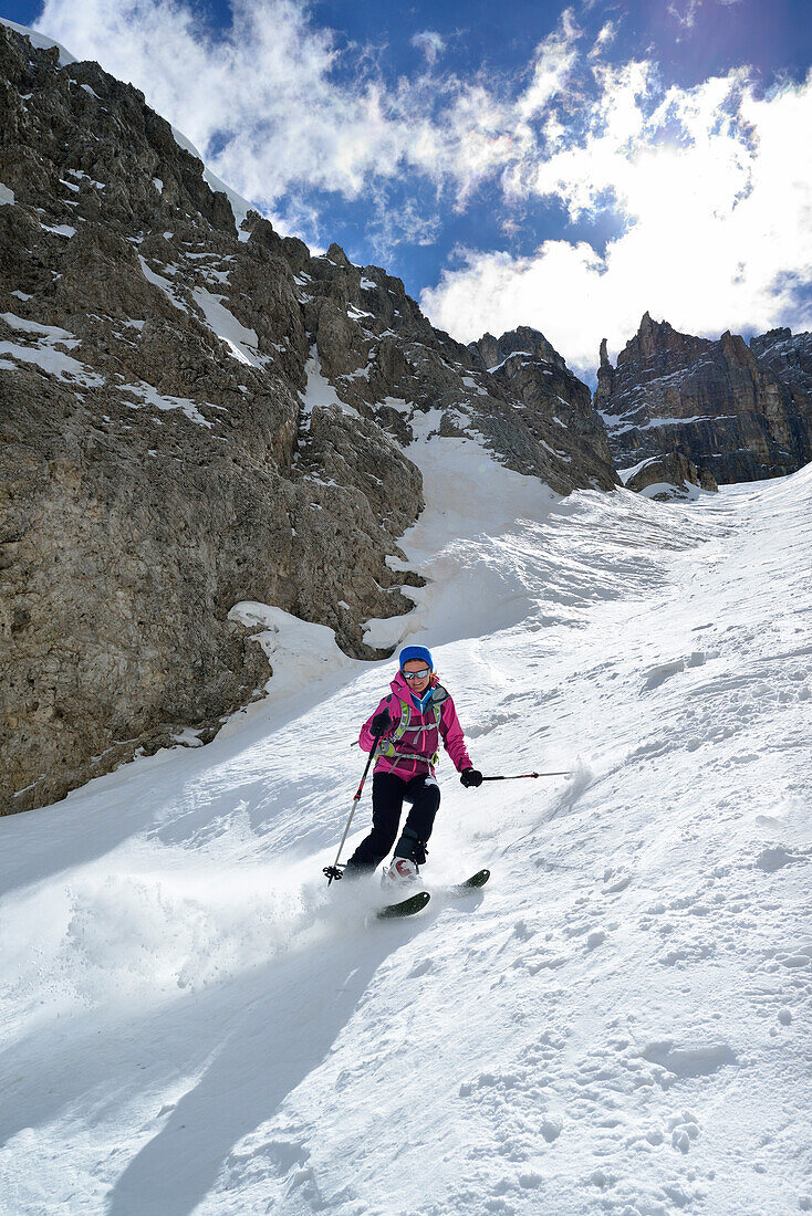 Female back-country skier downhill skiing through Val Setus, Sella Group, Dolomites, South Tyrol, Italy