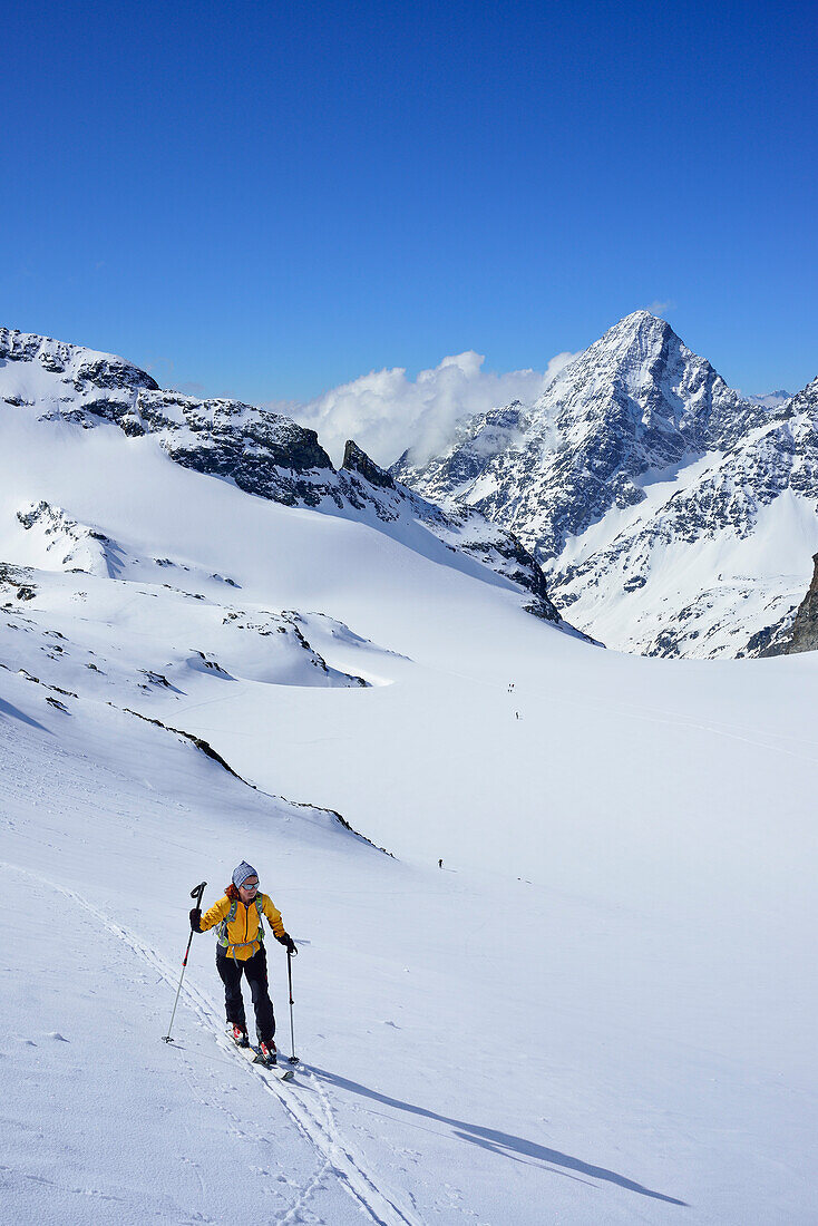 Frau auf Skitour steigt zum Piz Buin auf, Piz Linard im Hintergrund, Silvretta, Unterengadin, Engadin, Kanton Graubünden, Schweiz