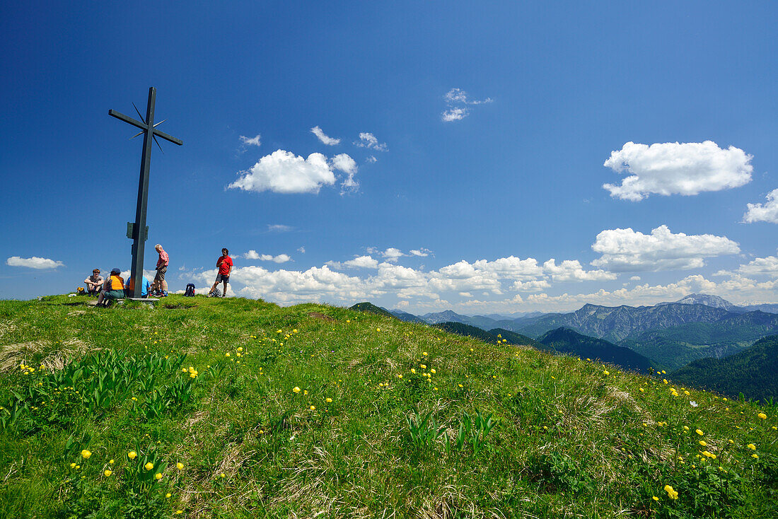 Wanderer rasten am Gipfelkreuz des Ochsenkamp, Bayerische Voralpen, Oberbayern, Bayern, Deutschland
