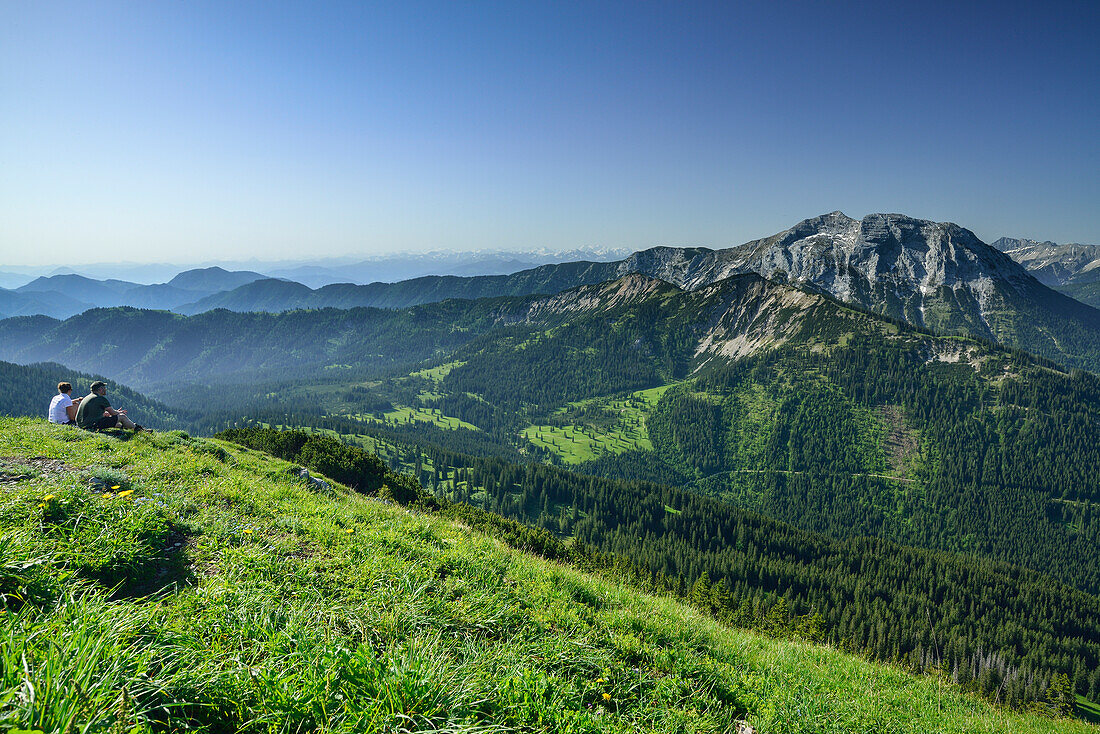 Two hikers sitting on summit of Halserspitz, Guffert in background, Blauberge, Bavarian Alps, Upper Bavaria, Bavaria, Germany