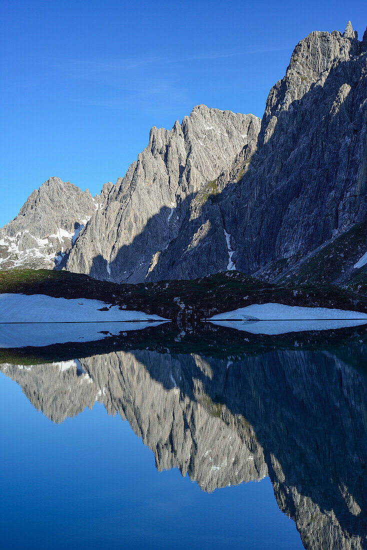 Reflection of Steinkarspitze in lake Steinsee, Lechtal Alps, Tyrol, Austria