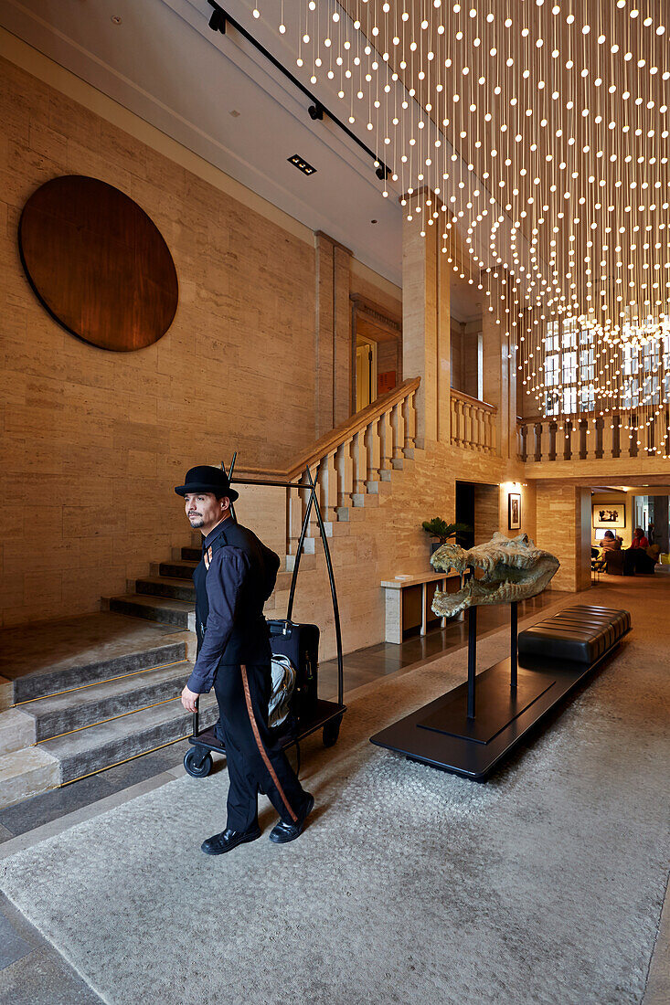 Page boy Fabian Enrique Flores Islas welcoming guests in the lobby of Das Stue Hotel, Drakestrasse 1, Tiergarten, Berlin, Germany