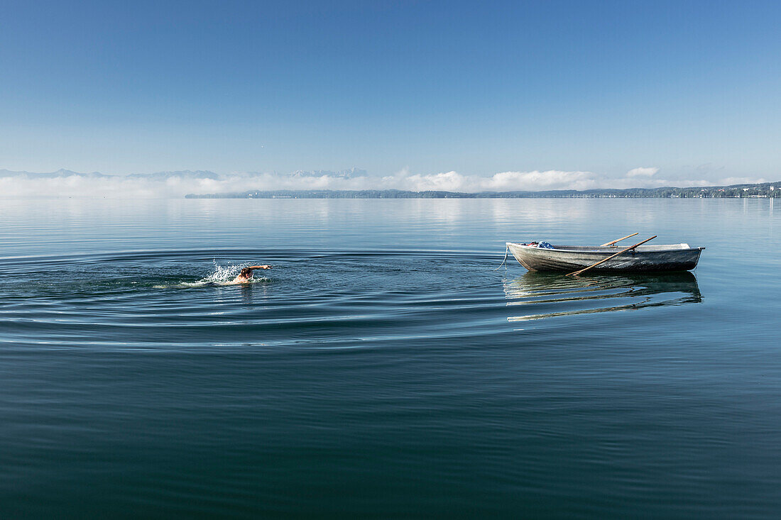 Mann schwimmt im Starnberger See, Alpen mit Zugspitze im Morgennebel, Berg, Oberbayern, Bayern, Deutschland