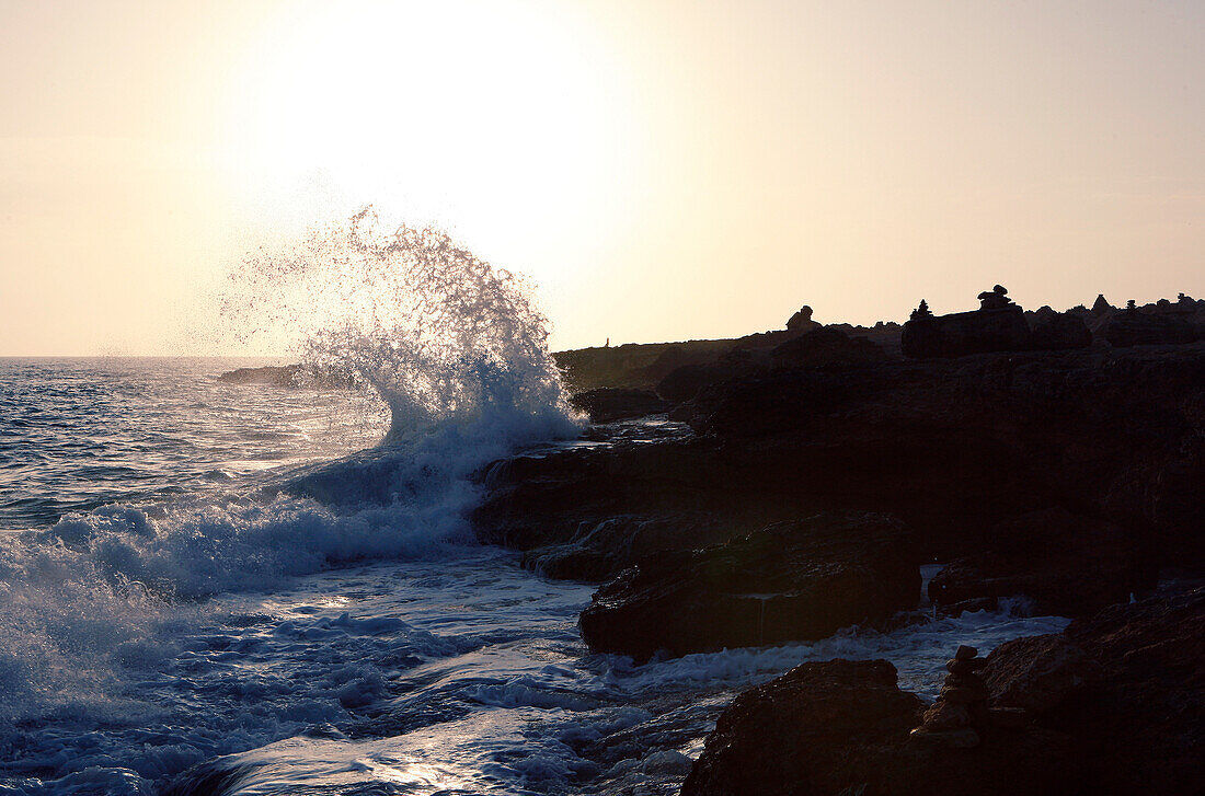 Wave crashing onto rocky coastline at sunset, near Santanyi, Mallorca, Balearic Islands, Spain, Europe