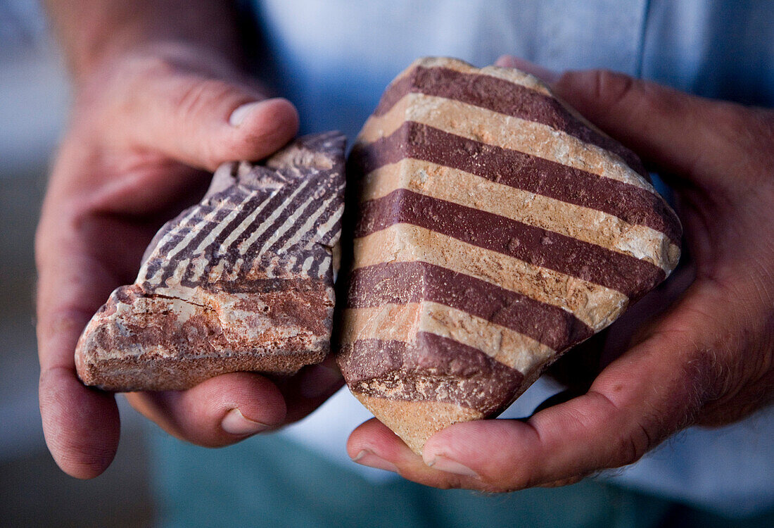 Two hands holding a Zebra Rock, rare stones only found at Lake Argyle, Lake Argyle, near Kununurra, Western Australia, Australia