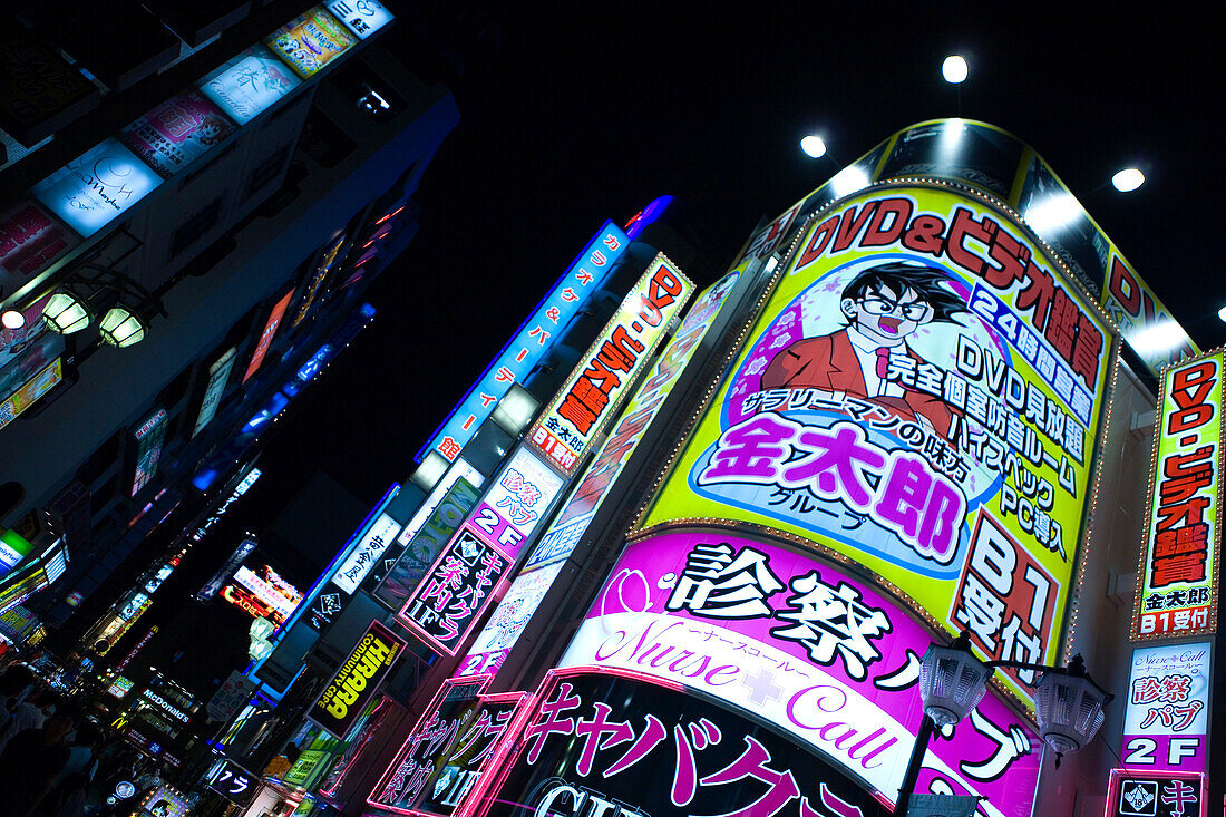 Bunt beleuchtete Werbetafeln an einer belebten Straßenkreuzung bei Nacht, Tokio, Region Kanto, Honshu, Japan