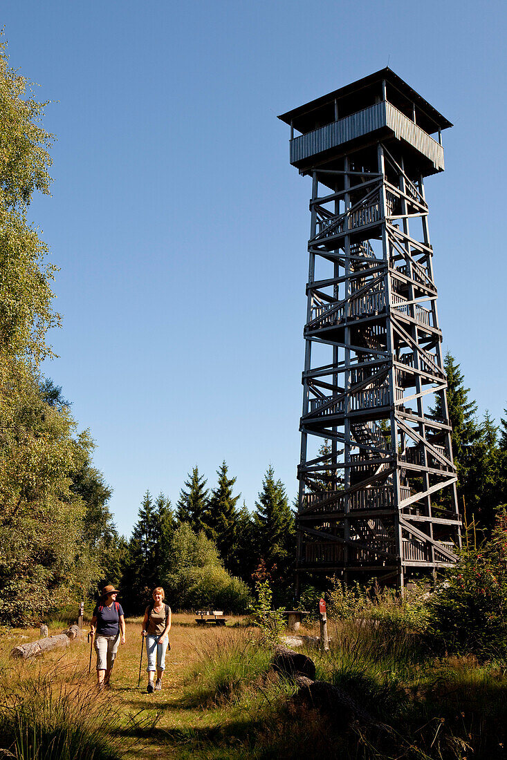 Zwei Frauen wandern entlang des Kellerwaldsteig am Fuß des Kellerwaldturms am Wüstegarten im Nationalpark Kellerwald-Edersee, Nordhessen, Hessen, Deutschland, Europa