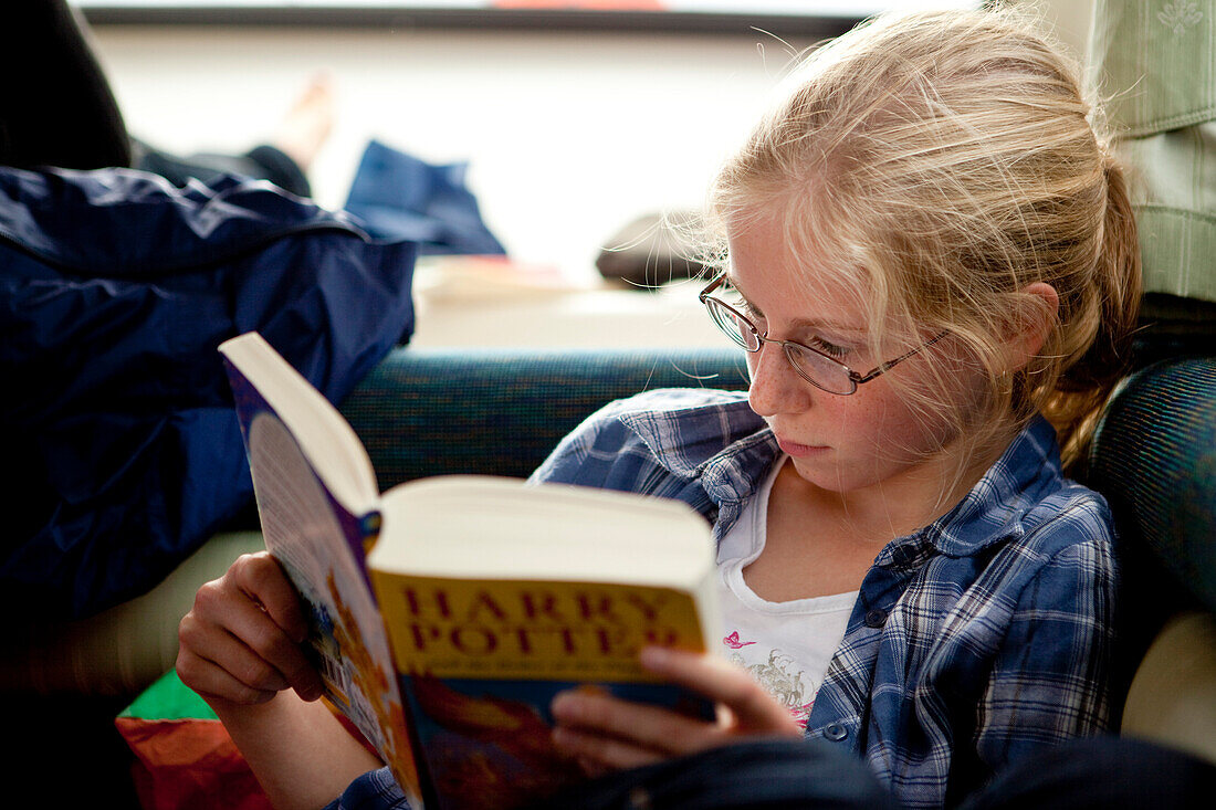 Young girl reading Harry Potter book intensely, Athlone, County Offaly, Ireland, Europe