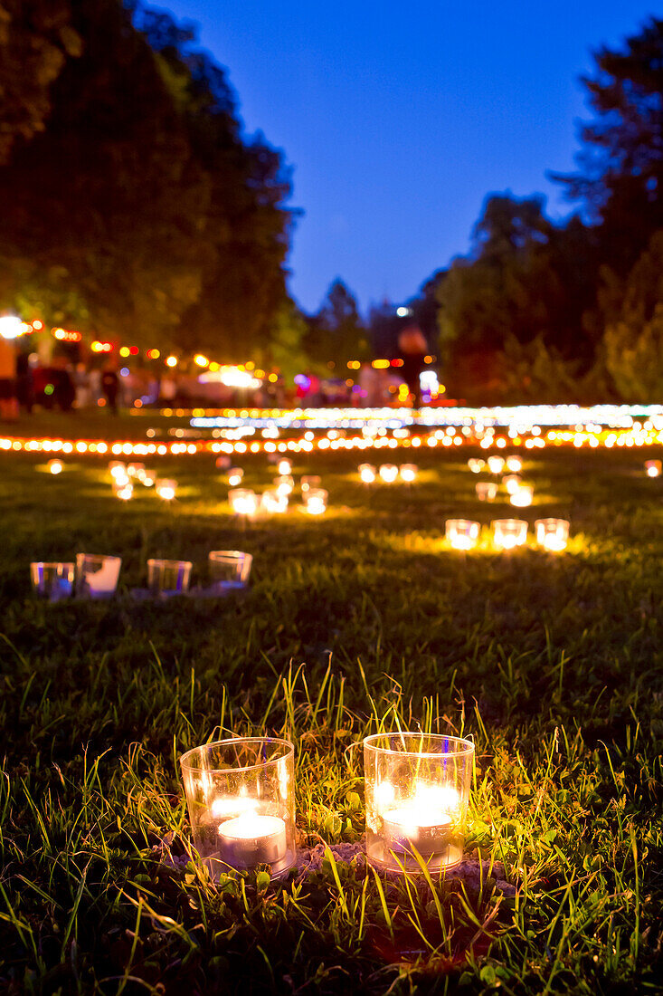 Zwei Kerzen stehen im Vordergrund, Tausende von Teelichtern im Hintergrund beim Lichterfest im Kurpark Bad Wildungen in der Dämmerung, Bad Wildungen, Nordhessen, Hessen, Deutschland, Europa