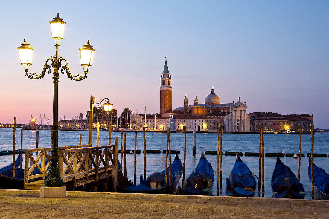 Gondolas along Bacino di San Marco and view of Isola di San Maggiore island with Chiesa di San Maggiore church at dawn, Venice, Veneto, Italy, Europe