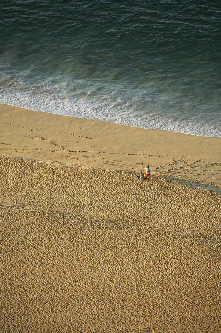 A lone surfcasting fisherman tries his luck along the Pacific beach at Cabo San Lucas in Baja, Mexico. Photo by Harrison Shull/Aurora