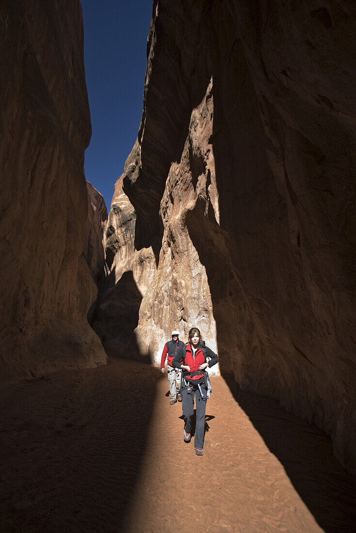 Briana Ratterman and Dallas Golz hiking Lomatium canyon loop in the Fiery Furnace, Arches National Park, Utah.