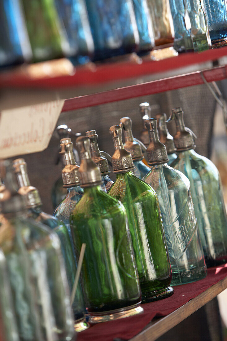Blue and green glass soda siphons for sale at a market in Buenos Aires, Argentina.