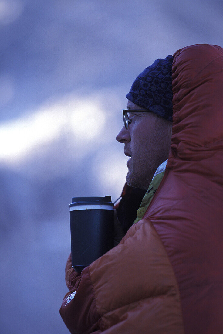 Dan Duane enjoying a hot drink in his sleeping bag while on a backpacking trip on the Sierra High Route, a 195 mile trackless path almost entirely between 9,000 and 11,500 feet in elevation in the Eastern Sierra Nevada mountains in California.