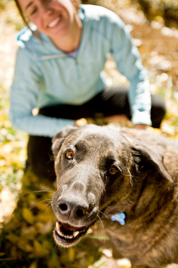 Tina Sommer and  her dog Roxy take a break while trail running on the trails near Santa Fe, New Mexico in the fall season.