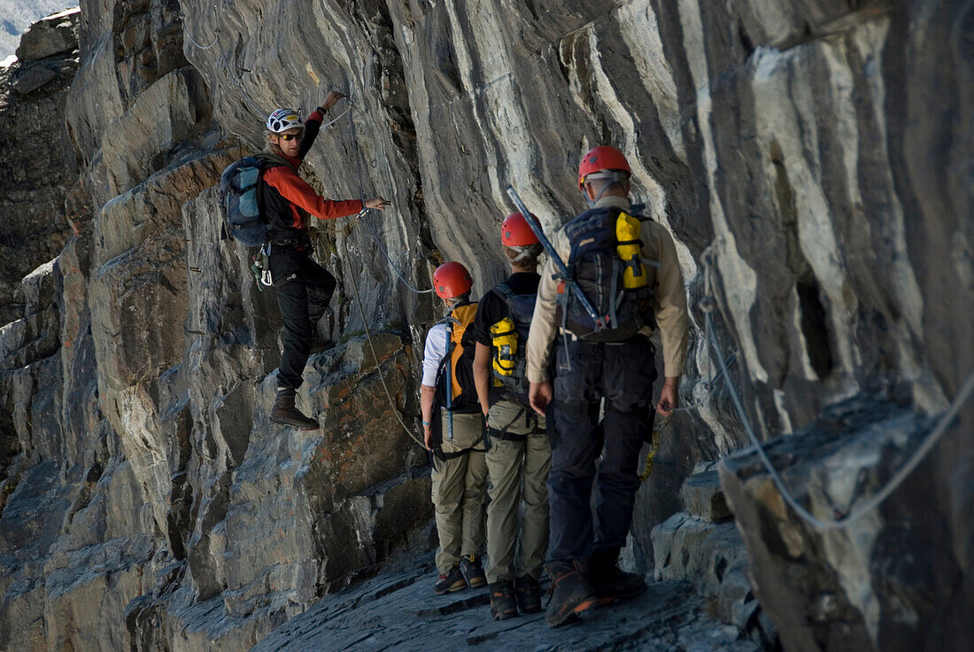 A group of climbers including is guided through some steep terrain in the Canadian Rockies, British Columbia, Canada.