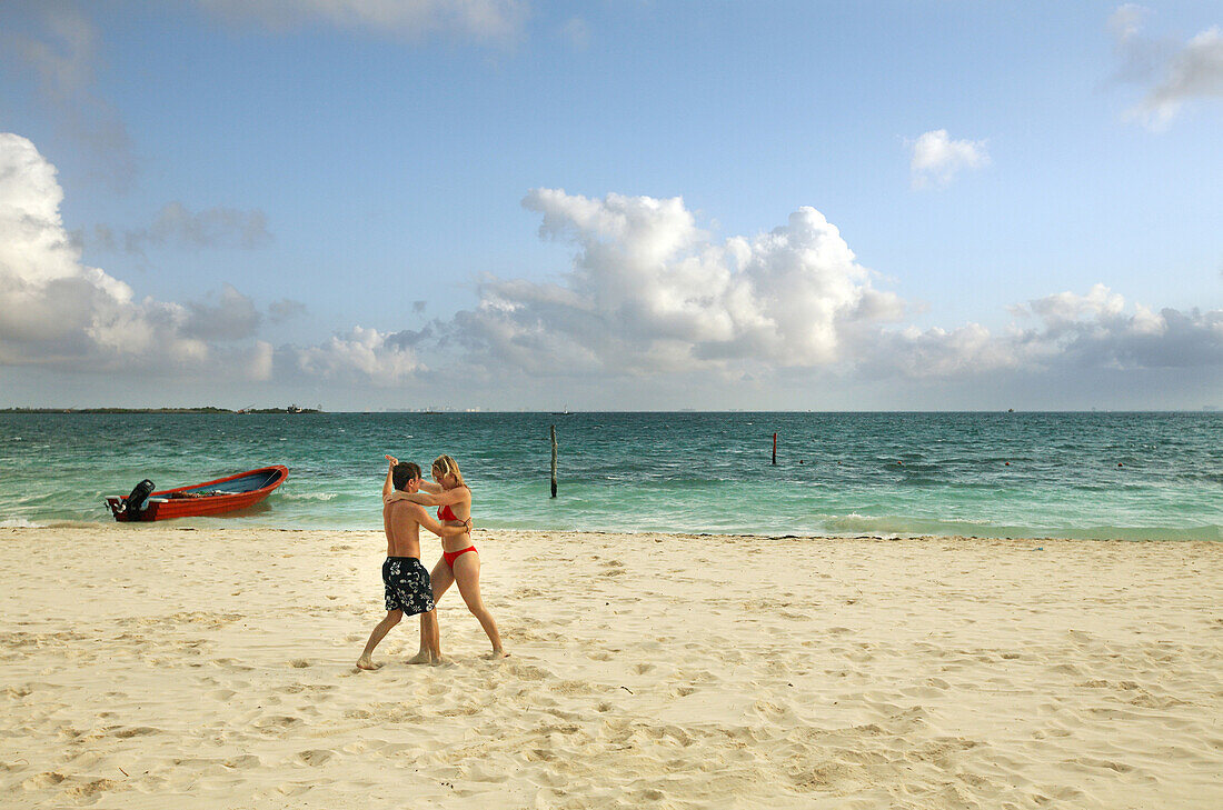 A couple dances on a beach of Isla Mujeres, near Cancun, Mexico. The area is known for it's beautiful beaches, first-class resorts and outdoor, nautical activities.