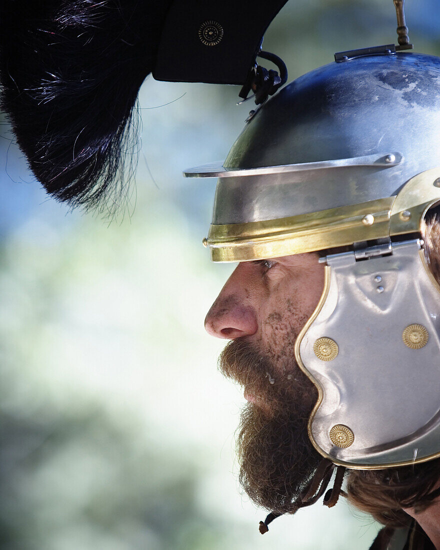 Close up side view portrait of a man wearing a metal helmet with headdress, looking like a medieval warrior. California. releasecode: rrk_mr164