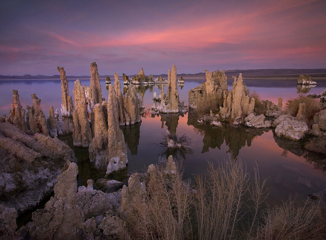 Tufa formations, towering remnants created by the upwelling of mineral deposits that formed underwater, make for an interesting and otherworldly scene at twilight along the shore of California's Mono Lake.