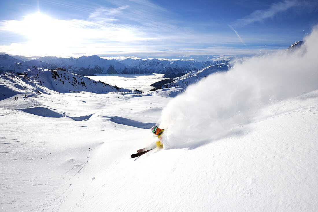 Skifahrer zieht Schneefahne hinter sich her, Kaltenbach, Zillertal, Österreich