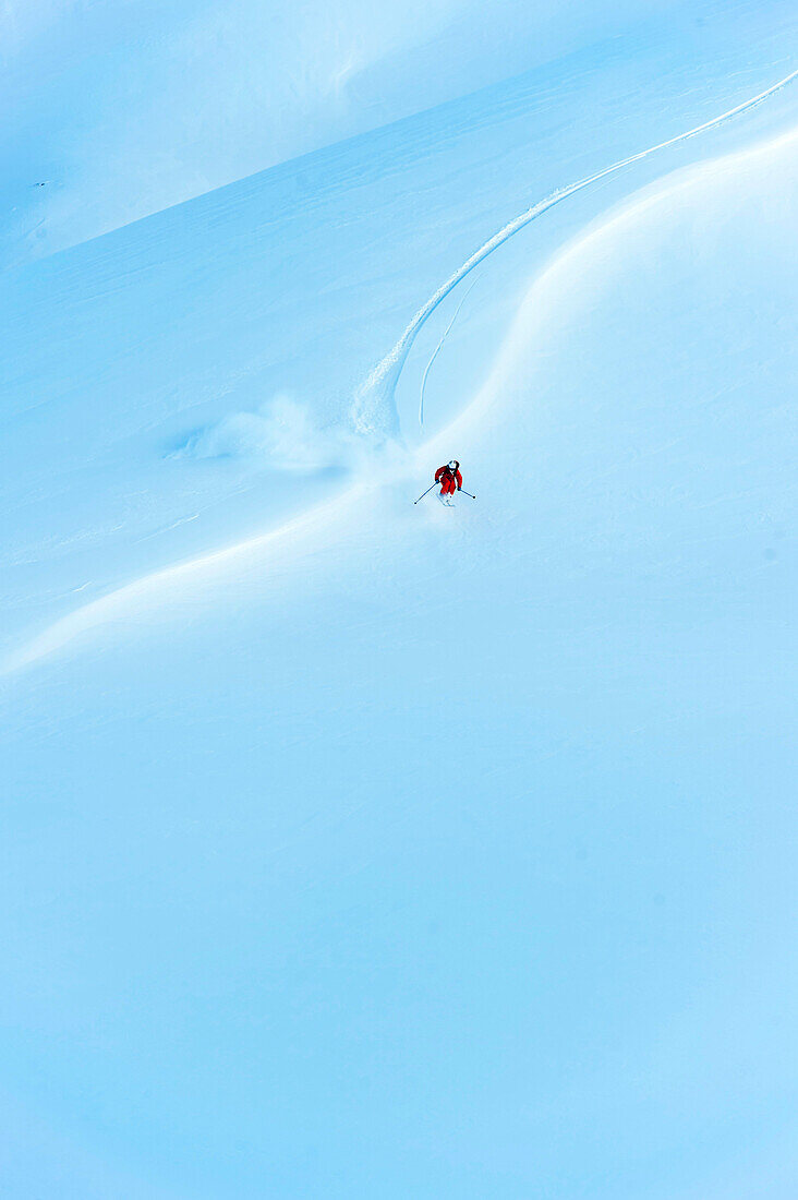 Skifahrer springt auf weiter Fläche über kleine Windlippe, Gargellen, Vorarlberg, Österreich