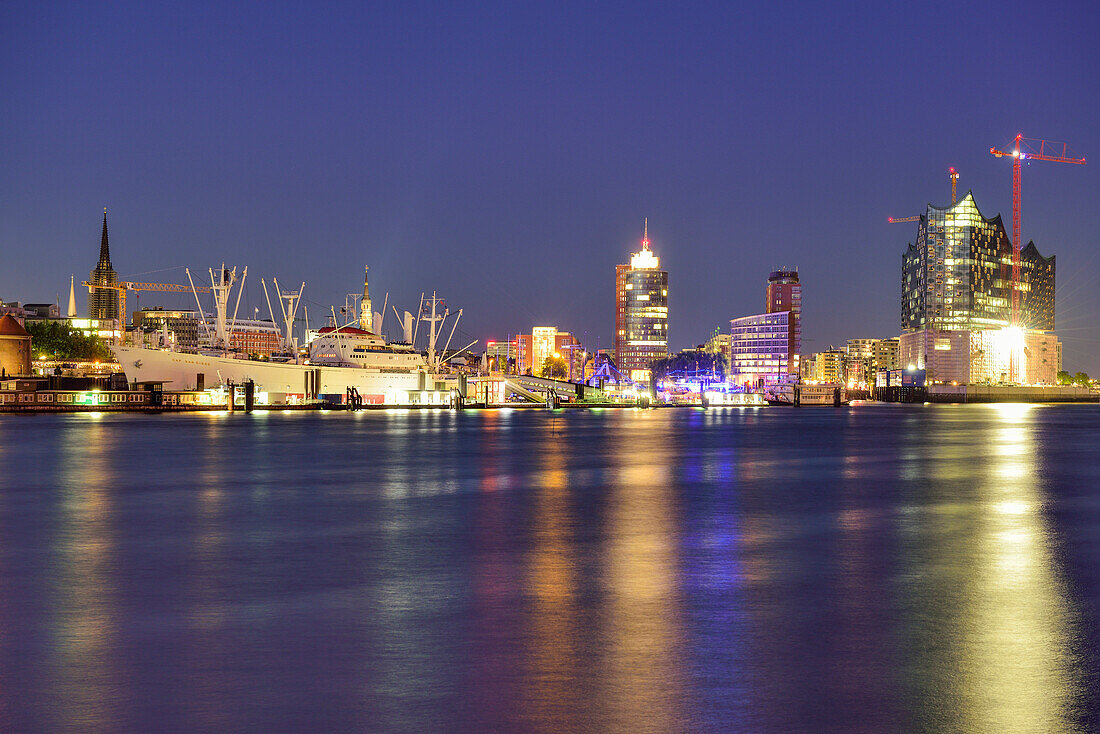 River Elbe at night with view to the church of St. Nicolai, church of St. Katharinen, museum ship Cap San Diego, Hanseatic Trade Center and Elbphilharmonie, Hamburg, Germany