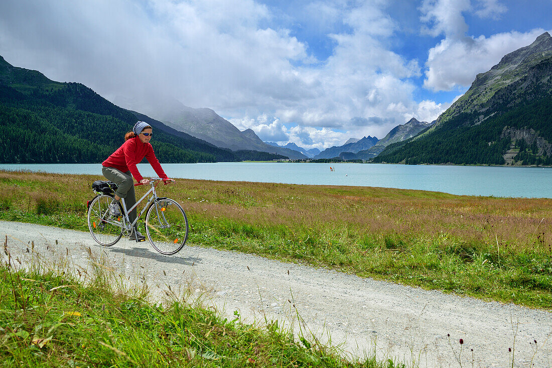 Radfahrerin fährt am Silvaplaner See entlang, Oberengadin, Engadin, Kanton Graubünden, Schweiz